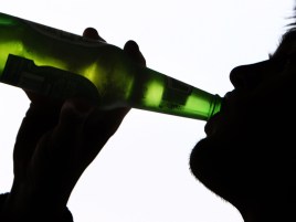 A person drinking a bottle of beer