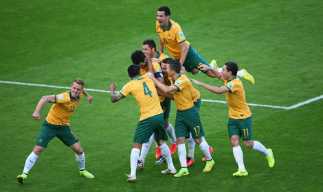 54th minute: Mile Jedinak is mobbed after converting his penalty. Photo: Getty