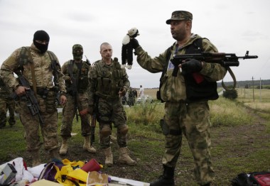 A pro-Russian rebel holds up a toy found at the crash site. Source: AAP.