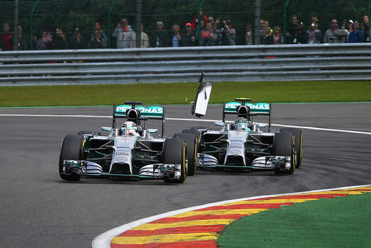 Debris flies as Nico Rosberg clips the rear tyre of teammate Lewis Hamilton. Photo: Getty