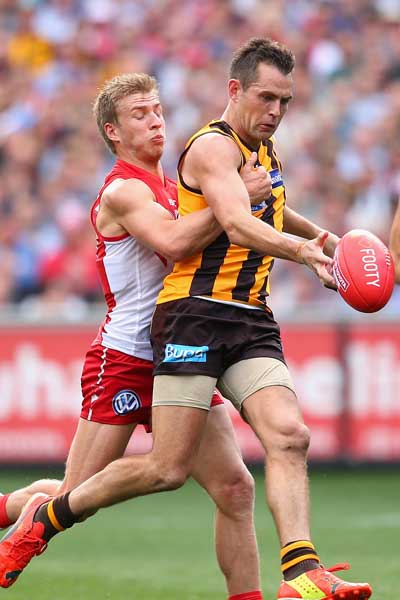 Norm Smith medallist Luke Hodge gets a kick away under pressure. Photo: Getty