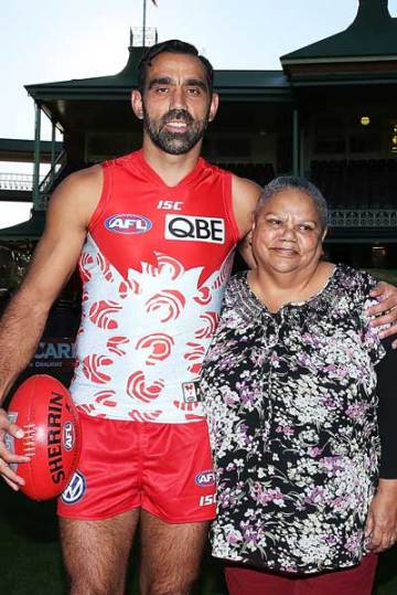 Adam Goodes, his mother Lisa Sansbury and the Indigenous Round guernsey she designed. Photo: Getty