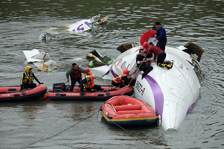 Rescue personnel work to free passengers from a TransAsia ATR 72-600 turboprop plane that crash-landed into a river outside Taiwan's capital Taipei on Wednesday. Photo: Getty