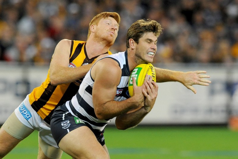 Tom Hawkins of Geelong takes a mark ahead of Kyle Cheney of Hawthorn. Photo: AAP