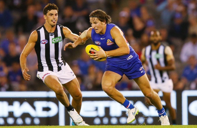 Marcus Bontempelli of the Bulldogs kicks the ball away from Dane Swan of the Magpies. Photo: Getty