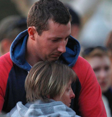 Stephanie Scott's fiance Aaron Leeson-Woolley is consoled by family as he visits the memorial.