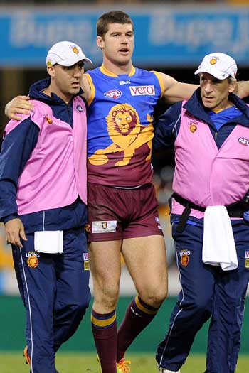 A too-familiar site: Jonathan Brown being helped off in a daze. Photo: Getty
