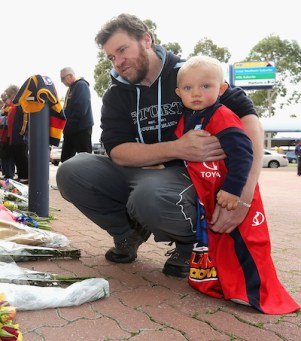 A tiny fan visits AAMI Stadium to mourn Walsh. Photo: Getty