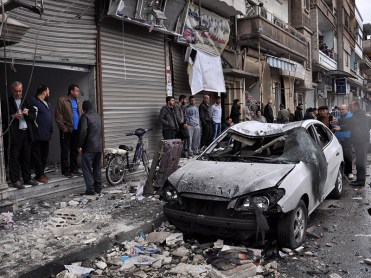 Syrian residents and security forces inspect the damage following a car bomb explosion on April 10, 2015, in the government-controlled majority Alawite neighbourhood of Hay al-Arman, located on the outskirts of the Zahraa district in Homs city. One child was killed and at least 10 people were wounded in the explosion, the Syrian Observatory for Human Rights said. AFP PHOTO / STR (Photo credit should read -/AFP/Getty Images)