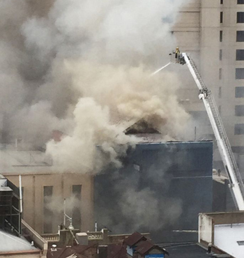 Firefighters tackle the fire from above.