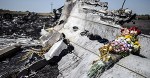 This photo taken on July 26, 2014 shows flowers, left by parents of an Australian victim of the crash, laid on a piece of the Malaysia Airlines plane MH17, near the village of Hrabove (Grabove), in the Donetsk region. Ukraine sought on July 25 to avoid a political crisis after the shock resignation of its prime minister, as fighting between the army and rebels close to the Malaysian airliner crash site claimed over a dozen more lives. Dutch and Australian forces were being readied on July 26 for possible deployment to secure the rebel-held crash site of the Malaysia Airlines flight MH17 in east Ukraine where many victims' remains still lie nine days after the disaster claimed 298 lives. AFP PHOTO/ BULENT KILIC
