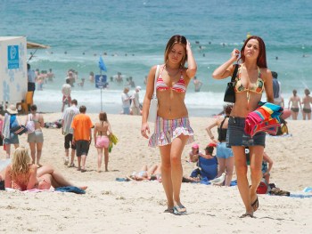Gold Coast, November 23, 2003. School leavers Ashlee Petroff (left) and Nicole Chadwick (right) of the Gold Coast enjoy the beach at Surfers Paradise on Queensland's Gold Coast today, following last night's first night of partying at schoolies week. Annually approximately 50,000 school leavers from NSW, Victoria and Queensland converge on the Gold Coast for a week of celebration after finishing their schooling. More than 30,000 people were estimated to have turned out for last night's celebrations. (AAP Image/Tony Phillips) NO ARCHIVING