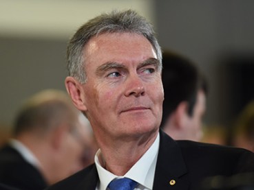The Director General of ASIO, Duncan Lewis, listens to Attorney-General George Brandis addressing the National Press Club in Canberra, Wednesday, Oct. 1, 2014. (AAP Image/Lukas Coch) NO ARCHIVING