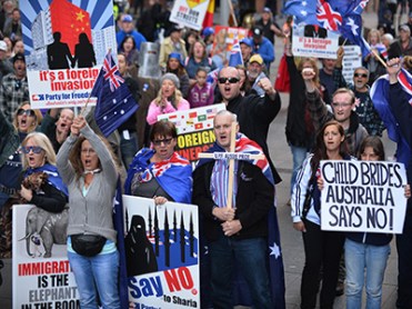 Nationalist demonstrators protest at a "Reclaim Australia" rally against Islamic extremism in Sydney on July 19, 2015. Reclaim Australia held rallies around the country in which hundreds of people, many waving Australian flags and carrying signs demonstrated against Islamic extremism which also prompted counter anti-racism protests. AFP PHOTO / Peter PARKS (Photo credit should read PETER PARKS/AFP/Getty Images)