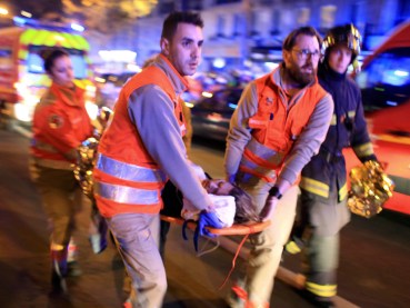 A woman is being evacuated from the Bataclan theater after a shooting in Paris.