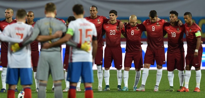 Portuguese and Russian players observe a minute's silence before their friendly. Photo: AAP