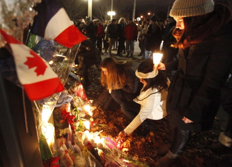 Mourners lay flowers in front of the French Embassy in Ottawa. Photo: Getty