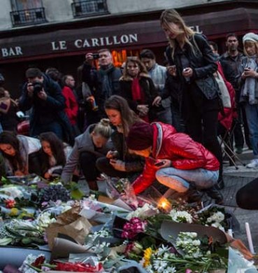 Mourners leave candles in front of the Petit Cambodge restaurant near Le Carillon restaurant where attacks took place.