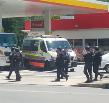 Heavily armed police patrol the Shell service station. 
