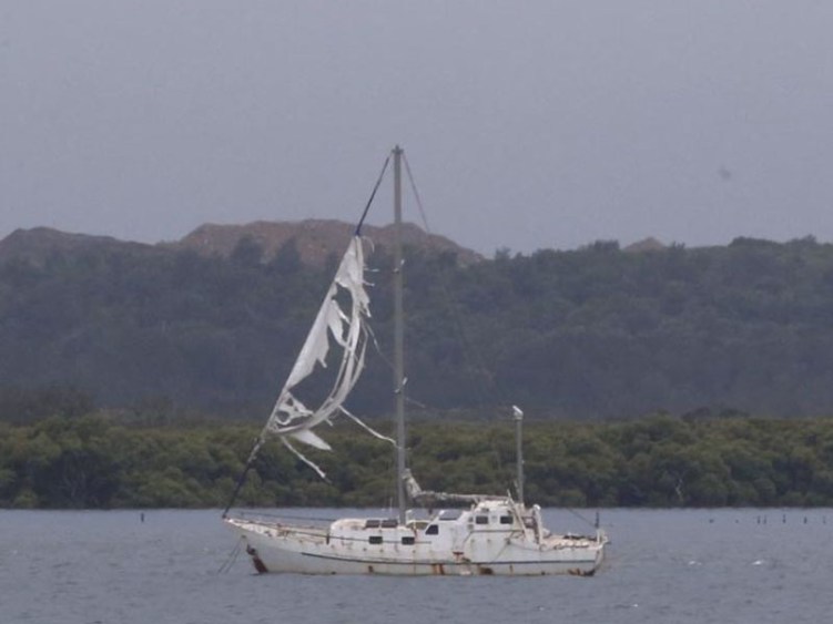 A yacht's torn sail flaps in the wind after the storm passed over Kurnell.