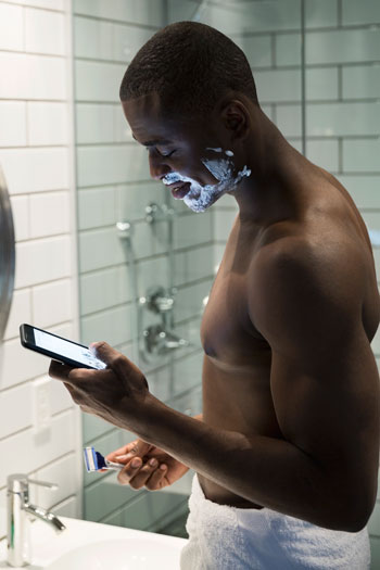 Some people have a hard time getting through a shave without checking Tinder for matches. Photo: Getty