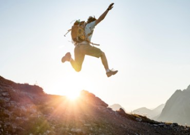 backpacker man sun jump happy