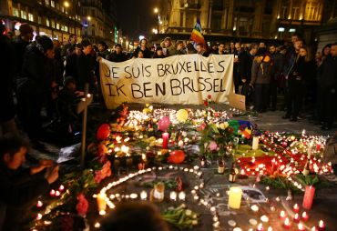 People hold up a banner as a mark of solidarity at the Place de la Bourse in Brussels.