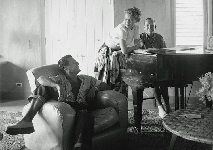 Noel Coward (at the piano) relaxes with friends in his home on Firefly. Photo: Getty