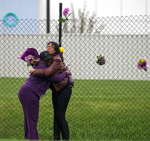 Mourners embrace outside Paisley Park. Photo: Getty