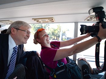 A photographer takes a picture of herself with Prime Minister Kevin Rudd while on the media bus in Brisbane, Tuesday, Aug. 6, 2013. The federal election will be held September 7. (AAP Image/Lukas Coch) NO ARCHIVING