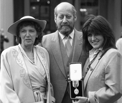 Clement Freud with wife Jill, (l) and daughter Emma receiving his knighthood in London in 1987. Photo: AAP.