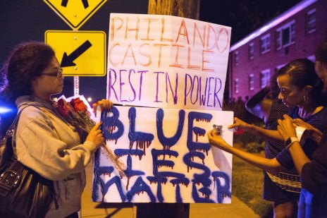 Protester's hang signs on a post near the scene of Philando Castile's shooting. Photo: AAP