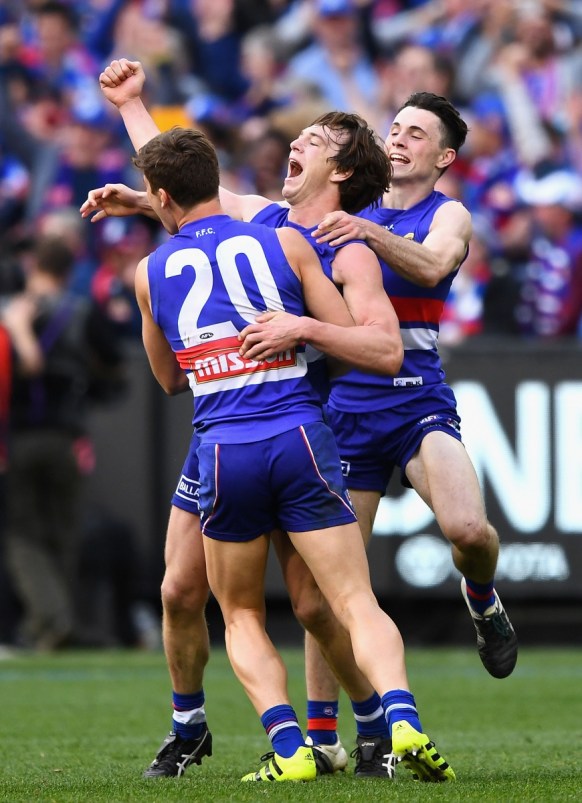 Liam Picken celebrates with Josh Dunkley and Toby McLean on the final siren.