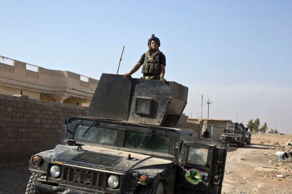 An Iraqi special forces soldier stands atop a Humvee in the village of Bazwaia, eight kilometres from the centre of Mosul.