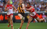 Taylor Duryea of the Hawks kicks whilst being tackled by Josh Kennedy of the Swans during the 2014 AFL Grand Final. Getty
