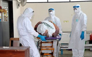 Thai health officers inspect the body of a British national suspected of having Ebola.