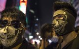 Masked protesters stand at the barriers dividing the police from the crowds in Hong Kong.