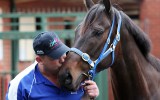 Trainer Peter Moody kisses undefeated champion racehorse Black Caviar before facing the media at the Moody racing stables in Caulfield, Thursday, Oct 6, 2011. AAP