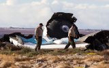 Law enforcement officials take a closer look at the wreckage near the site where a Virgin Galactic space tourism rocket, SpaceShipTwo, exploded and crashed. AAP