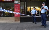 Police officers guard a crime scene following a robbery at a Sydney bank.