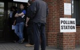 Members of the public wait to cast their votes at a polling station in Elvetham Heath in southern England