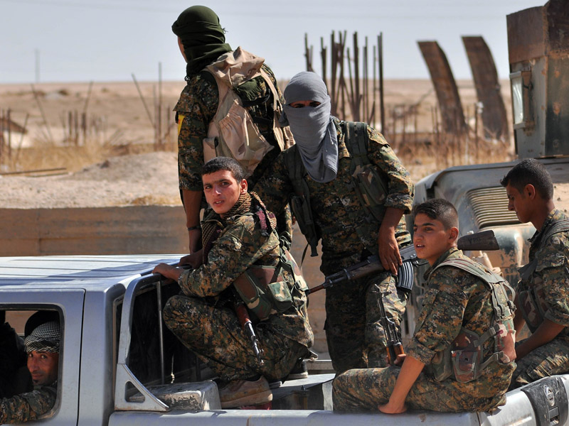 Kurdish People's Protection Units (YPG) fighter drives through Hasakeh.