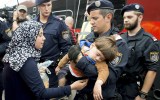 Policemen help children and mothers to board a train in Austria.
