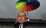 A man wearing a Prime Minister Tony Abbott mask at a Oxfam protest against climate change outside Parliament House in Canberra, Tuesday, June 16, 2015. (AAP Image/Mick Tsikas) NO ARCHIVING