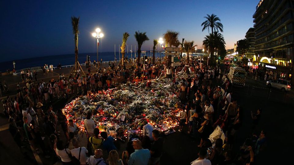 People gather at a makeshift memorial on the Promenade des Anglais in Nice.