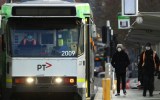 MELBOURNE, AUSTRALIA - JULY 23: People are seen at a tram stop on July 23, 2020 in Melbourne, Australia. Face masks or face coverings are now mandatory for anyone leaving their homes in the Melbourne metropolitan area or the Mitchell Shire. Under the new rule, which came into effect at midnight on Thursday, anyone failing to wear a mask in public can receive a $200 fine. Metropolitan Melbourne and the Mitchell shire remain in lockdown due to the rise in COVID-19 cases through community transmissions, with residents in lockdown areas under stay at home orders until 19 August. People are only able to leave home have for exercise or work, to buy essential items including food or to access childcare and healthcare.