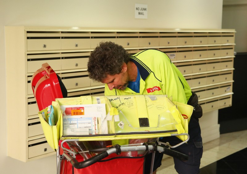 A postman delivers mail to a building in Surry Hills