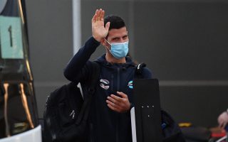Novak Djokovic waves as he arrives at Adelaide Airport on January 14, 2021 in Adelaide, Australia
