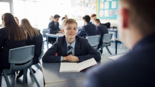 Point of view angle of teenage boy having a discussion during class.