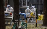 Workers wearing personal protective equipment (PPE) are seen by the entrance to a residential area under lockdown in Beijing
